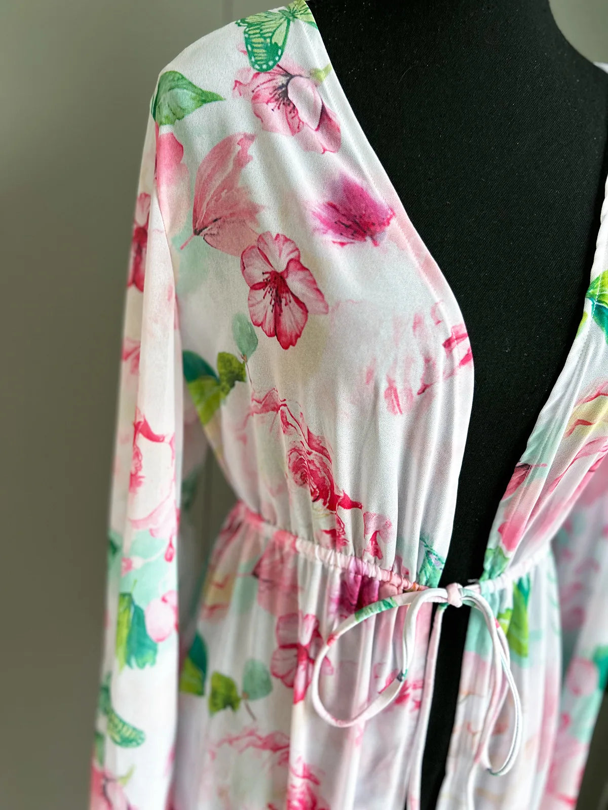 Floral patterned garment on a mannequin against a neutral background