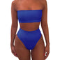 Flat lay of solid color strapless bikini set with accessories