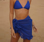 Model wearing black ruffle bikini cover up on sandy beach 