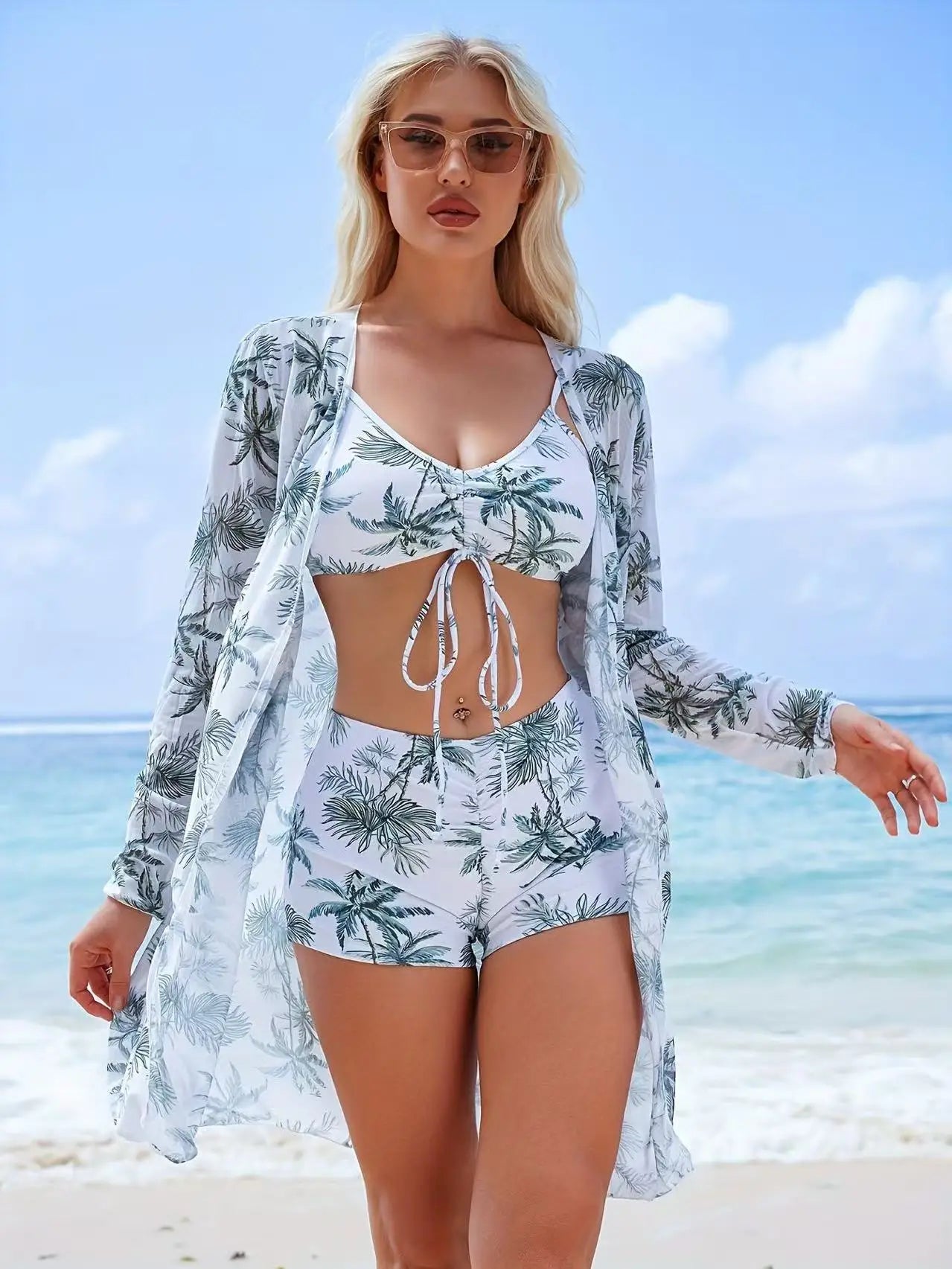  Model wearing Women's Siren Splash Three-Piece Tankini Set on a beach